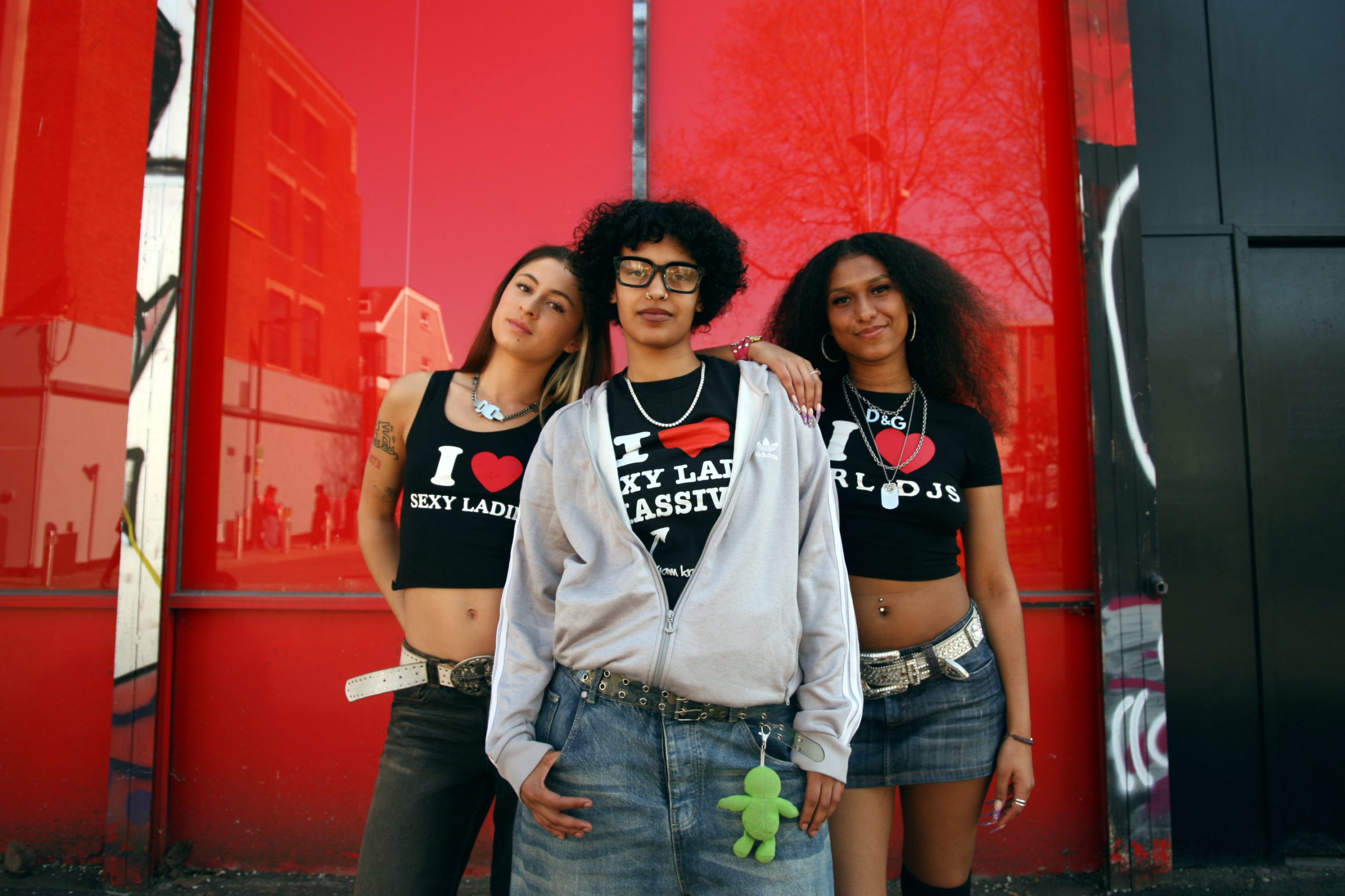 The three band member stood in front of a red wall