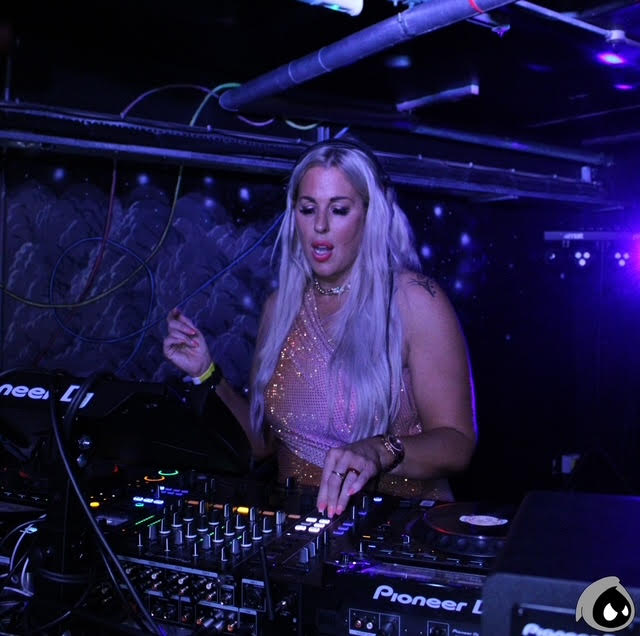 Kelli stood behind a dj deck