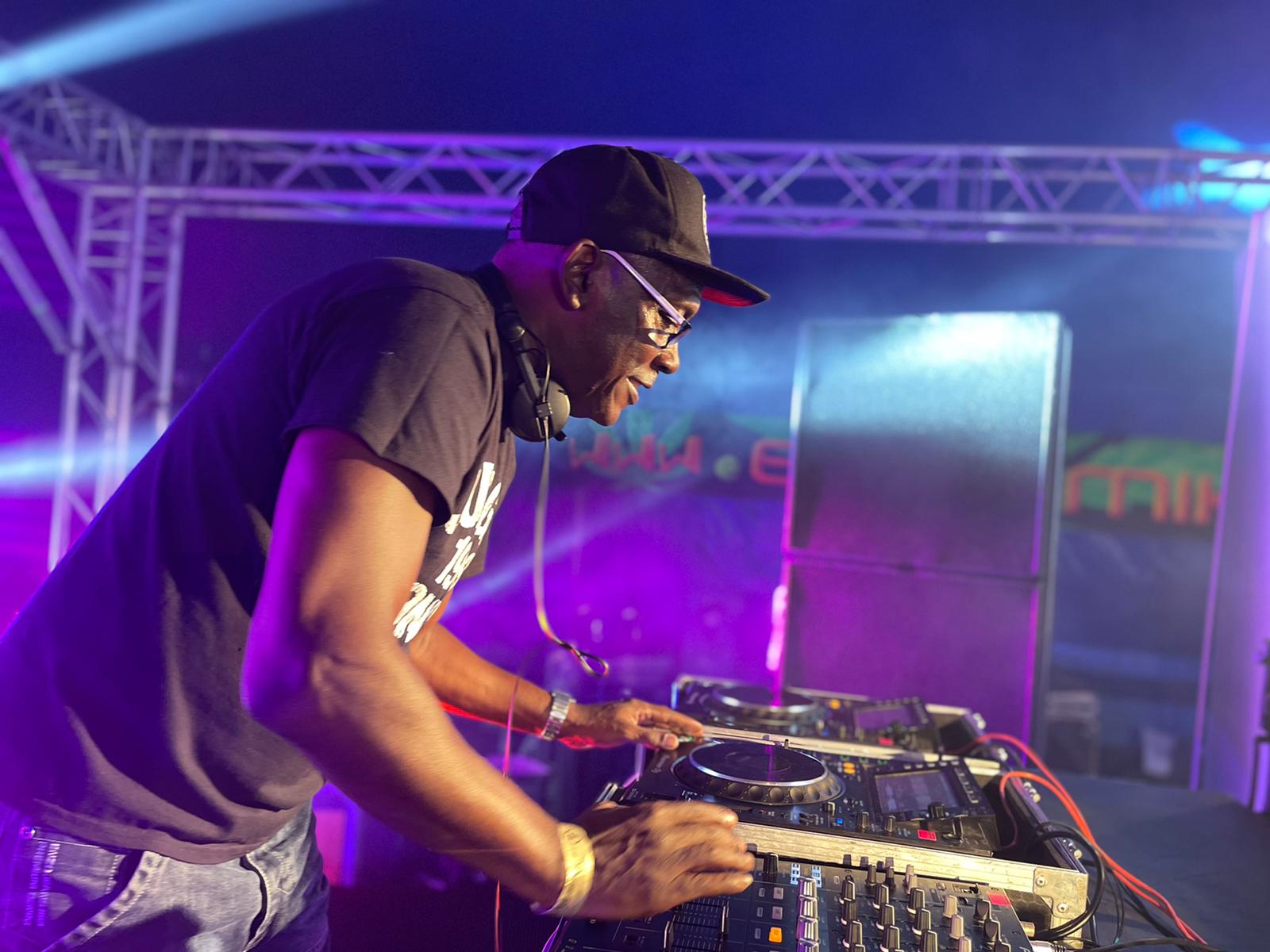 Kenny Ken leaning over mixers with a baseball cap on