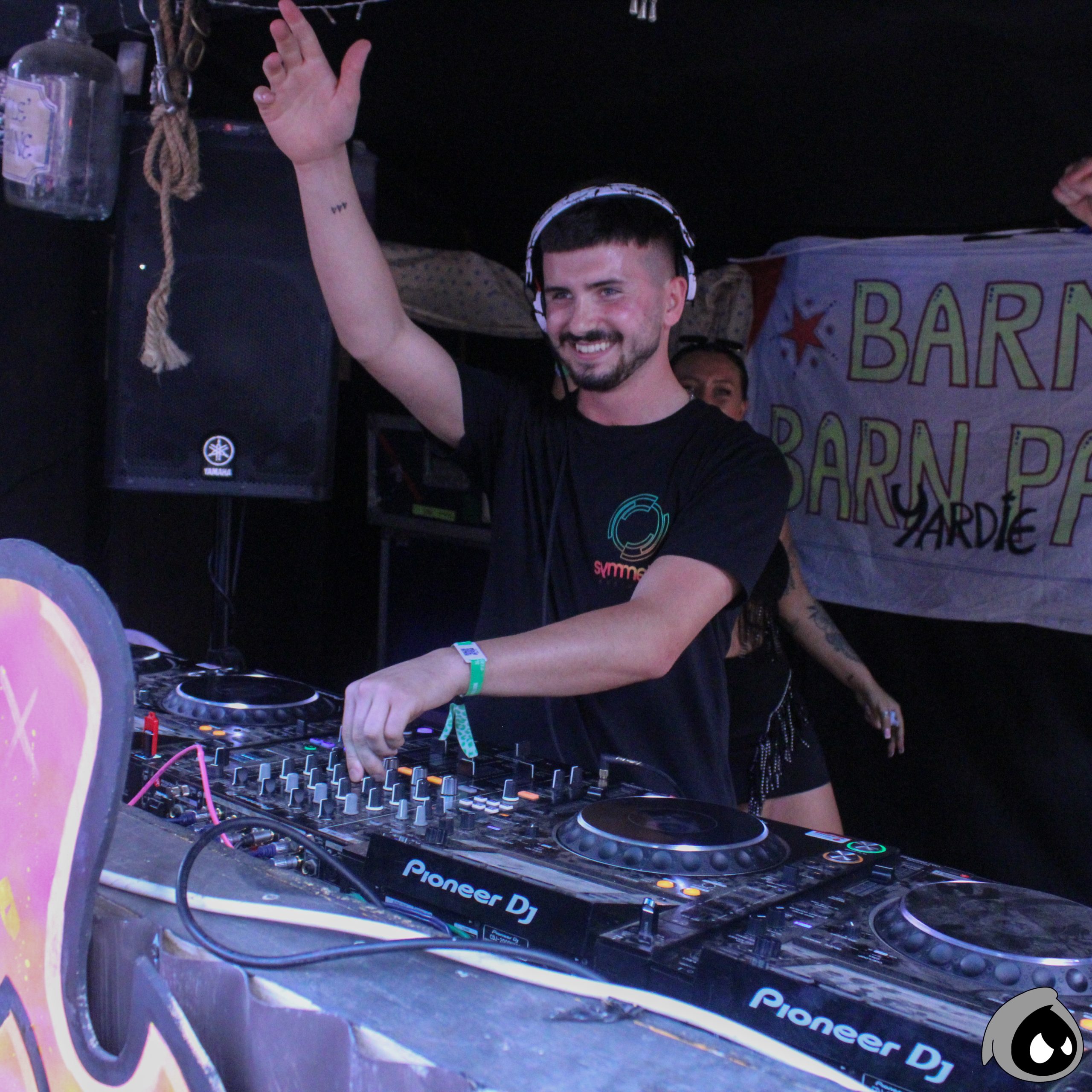Tang with his arm in the air, djing
